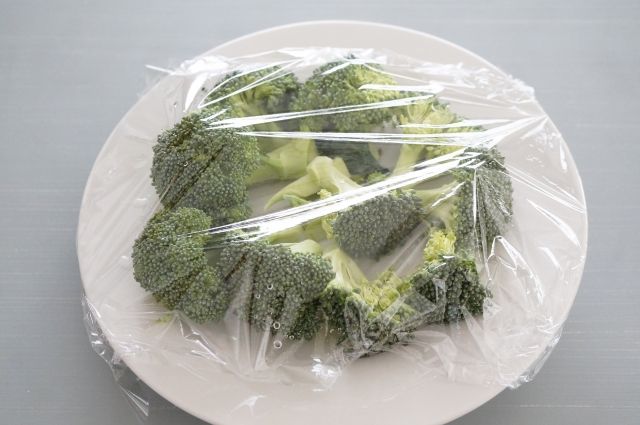 ラップをかけたブロッコリーが入ったお皿 電子レンジ調理イメージ