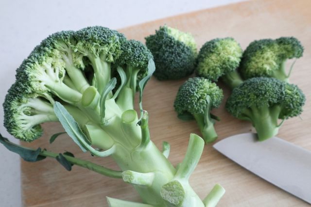 まな板の上のブロッコリー カット前と後 茎を分ける様子
