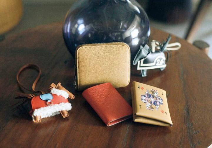 上段右から、たてがみや尾のフリンジなどの躍動感がたまらない馬チャーム。レーシングドレスの白のラインとナンバーがスポーティ。チャーム￥144,100、美しいレザーのシボが引き立つミニマルなスクエアシェイプ。ラウンドジップの開閉もスムーズ。ウォレット［H9.5×W11.5、カード入れ6］￥196,900、下段右から、トランプのクイーンをモチーフに、アートなセンスが息づくバランスと色使いはさすが。丸みのあるフォルムで気持ちよく手になじむ。ウォレット［H10.5×W7、カード入れ1、小銭入れ1］￥136,400、手に取るたびに元気になれるきれいな色。コンパクトで小ぶりのバッグにも収まりがいい。カードケース［H9.5×W7、カード入れ2］￥11 3,300、ふわふわのボアがついたケープを纏った姿にキュン。チャーム￥202,400（すべてエルメス／エルメスジャポン）