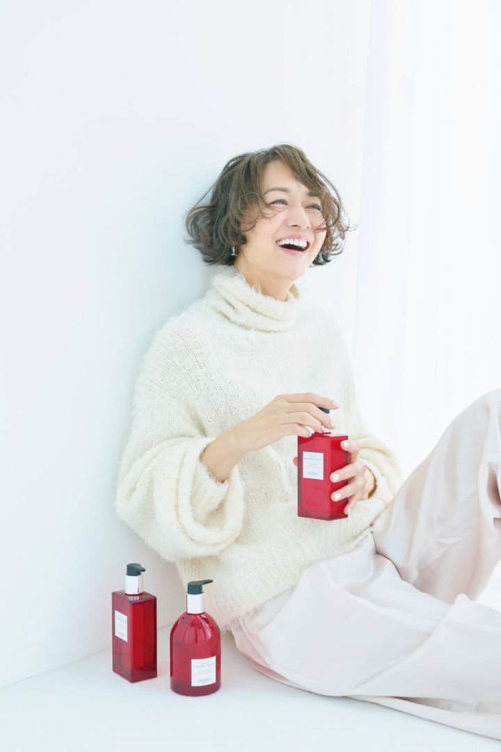 〈床置き右から〉「オー ドゥ ルバーブ エルカラット」ハンド＆ボディ クレンジングジェル¥11,110、同 ヘア＆ボディ シャワージェル¥11,000、〈手に持ったボトル〉同 モイスチャライジング ボディローション¥12,650／すべてエルメス（エルメスジャポン）、ニット¥39,600／カオス（Chaos GINZA SIX）、パンツ※参考商品／デパリエ（デパリエ 伊勢丹新宿店）、ピアス¥40,000／トムウッド（トムウッド 青山店）