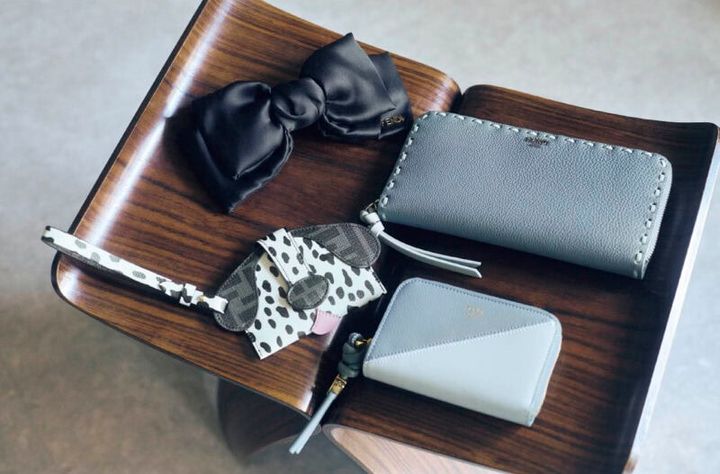 右上から、縁を飾るステッチは職人の手作業によるもの。引き手のレザーコードも洒落たアクセントに。カード入れや札入れが充実していて、しっかり収納、整理できる長財布。ウォレット［H8.5×W20×D2、カード入れ8］￥145,200、斜めのカラーブロッキングと、スライダーの結び目とコードがモードなインパクトを放つ。ウォレット［H8×W13×D2、カード入れ2］￥82,500、左上から、メタルロゴをのせたシルクサテンのビッグリボン。1点加えるだけで優雅な印象に。バレッタ￥90,200、「FF」ロゴのレザーとポルカドットのプリントレザーで犬の顔に！ ペロリと出ている舌がなんともラブリー。スナップ留めの鼻のベルトを外すと内側にコンパートメントが。ストラップ付なのでチャームとしても楽しめる。カードケース［H7.5×W13.5］￥71,500（すべてフェンディ／フェンディ ジャパン）