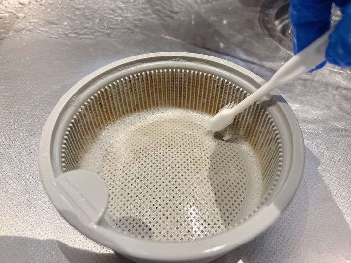 歯ブラシでゴミ受けをこする