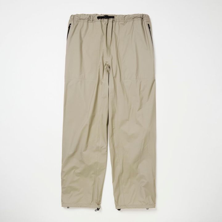 ⻑めのサイドジップを配したレインパンツ。ふくらはぎの裏側にあるドローコードは⾜の動きに合わせて裾が上がってくる現象を防⽌する役割を担う。