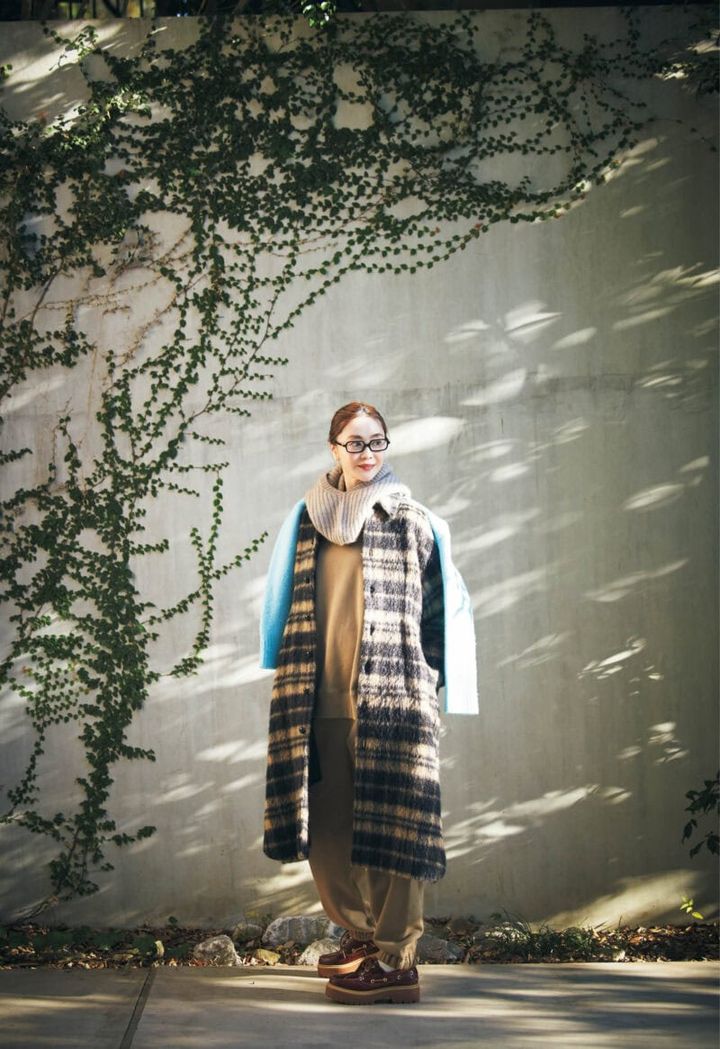 コート27万5000円（オブリオ） スエット2万8600円、パンツ3万800円（ともにハイク／ボウルズ） 肩にかけたニット3万9600円（プレインピープル／プレインピープル青山） バラクラバ7700円（リット／ピモンテ） 靴2万5300円（ティンバーランド／VF ジャパン） メガネ5万2580円（ミュウミュウ／ルックスオティカジャパン カスタマーサービス） ピアス16万5000円（カジャビジュー）