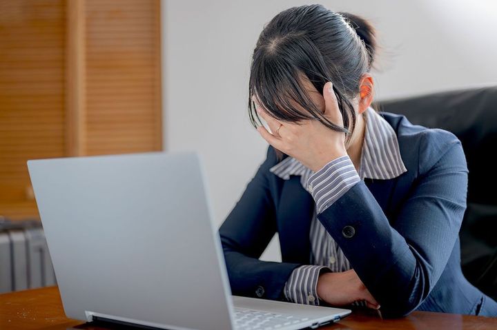 頭を抱えるビジネスウーマン