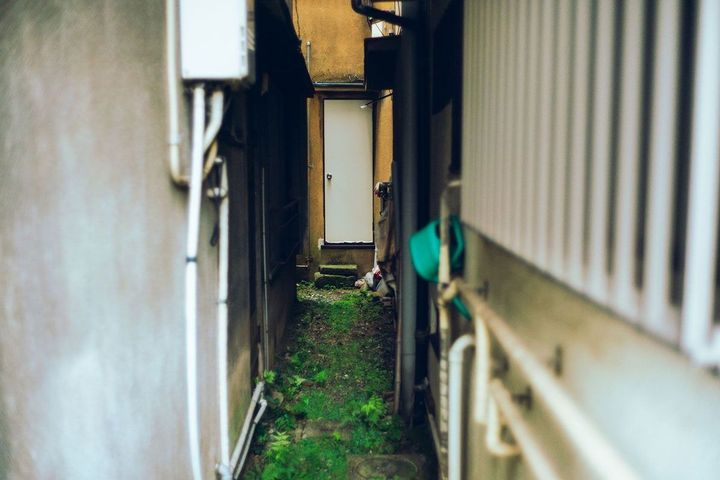 老朽化したアパートの後ろの狭い路地