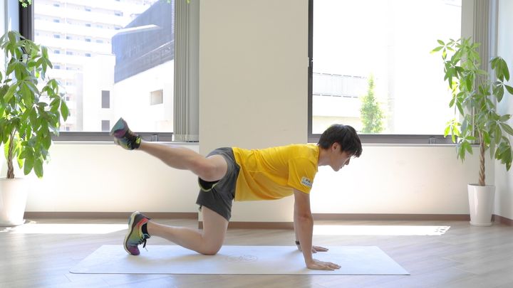 四つん這いで片膝を横に上げる