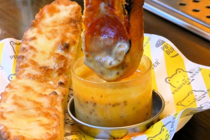 PERFECT BEER STAND 福岡 ピザをディップする様子
