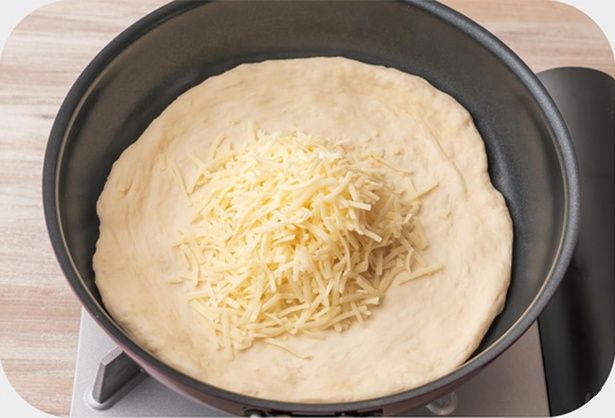 フライパンに生地を入れてのばし、ピザ用チーズをのせる （C）ぼく／KADOKAWA