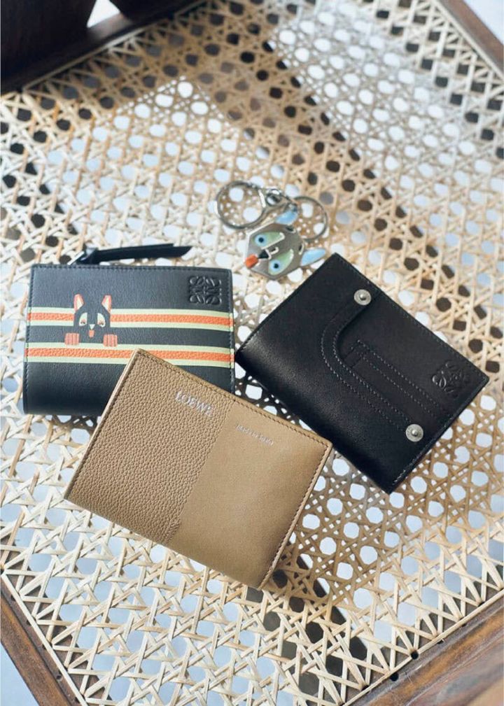 上から、ブルーの大きな目や耳、ぺろんと出した舌がファニー。シルバーカラーなので甘くなりすぎず、スタイリッシュにつけられそう。キーホルダー￥58,300、デニムのポケットやリベットを写したディテールが新鮮。美しいステッチを施した極上の仕上がりに職人技が宿る。ウォレット［H8・5×W11×D3、カード入れ6］￥115,500、オレンジ×アイボリーのダブルラインから顔を出す猫が愛らしい。インターシャ技法により耳や目、手などが立体的に浮かび上がる。ウォレット［H8・5×W11・4×D3、カード入れ6］￥115,500、シボとスムース、二つの表情の組み合わせがモダン。ウォレット［H8・5×W11・4×D3、カード入れ6］￥102,300（すべてロエベ／ロエベ ジャパン クライアントサービス）