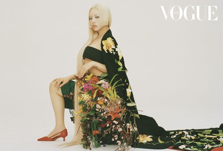 受け継がれる黒、咲きゆく花 黒地に大らかな百合が描かれた、豪華な引き振袖の着物。これは、江戸時代から続く本糸目友禅の伝統技法で染め上げられたハツコ エンドウ オリジナルの花嫁衣裳だ。その腰に重ねられたのは、東信の花飾り。「僕は、花という命のある存在を扱っているので、それをきちんと作品に乗せるようにしています。一番綺麗な部分だけを使うのではなく、少し萎れたところや、揺らぎのある表情も必ず入れる。そこに花の生やリアルが宿る。その儚さの中にも、日本らしさを感じているのかもしれません」。強さも脆さも隠さず、揺らぎのままに自分を咲かせるちゃんみなの凛とした佇まいが、花々と美しく咲き誇る。<br /> トップ ￥119,900 スカート ￥748,000 シューズ ￥192,500（すべて予定価格）／すべてPRADA（プラダ クライアントサービス） 引き振袖着物 ￥880,000（レンタル価格）／HATSUKOENDO（ハツコ エンドウ ウェディングス銀座）