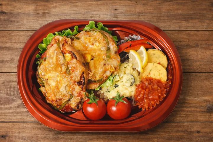 朱赤の容器に彩り豊かなおかずを盛り付けた気仙沼イタリアン弁当