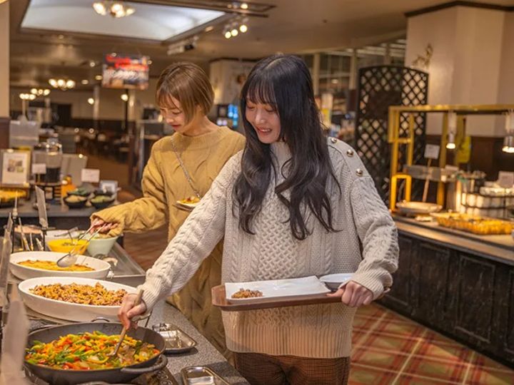 ビュッフェカウンターで料理を選ぶ女性2人