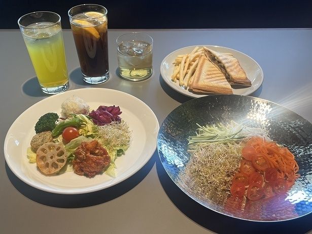 「ブッダボウル」(1080円・手前左)や「サウナス冷やし中華」(1080円・手前右)などプラントベースフードが食べられる