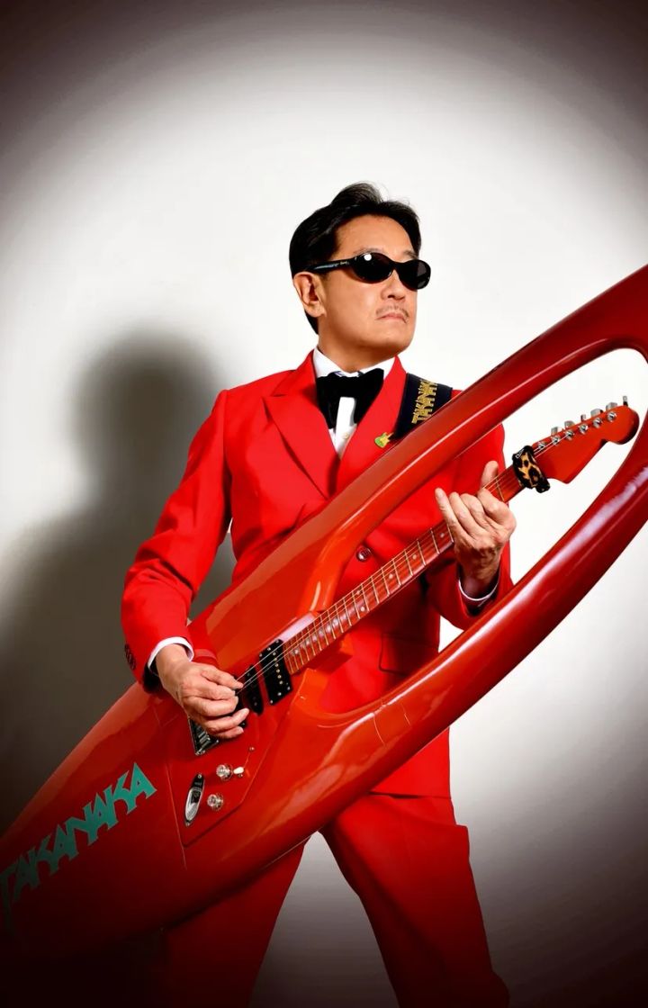 赤いスーツとギターで立つ高中正義のアーティスト写真
