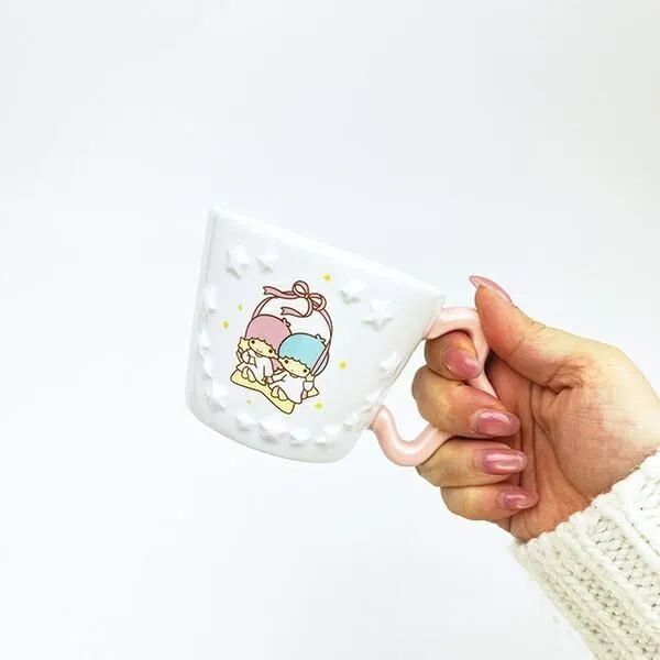 キキララの白いマグカップを手に持ったイメージ