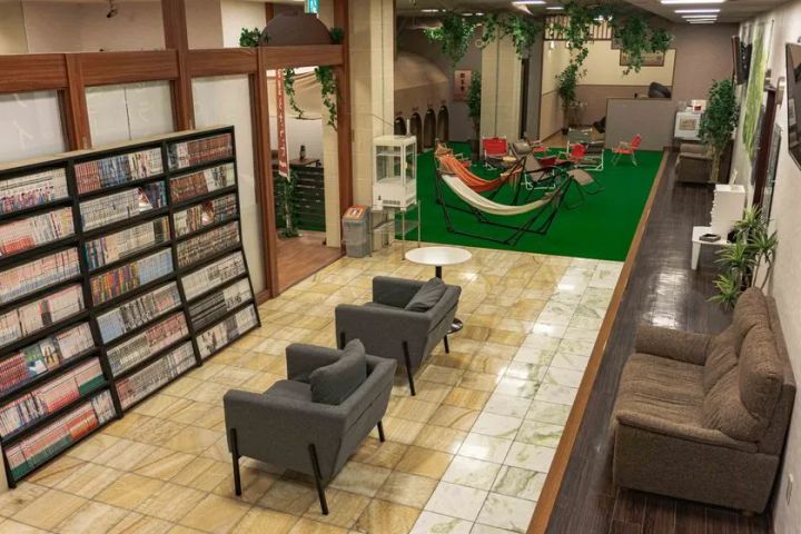 漫画本棚とソファが並ぶ広い休憩ラウンジ