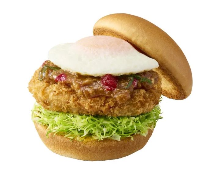 キャベツとメンチカツに赤いミンチソース、目玉焼き風トッピングを重ねた台湾ラーメン風メンチカツバーガー