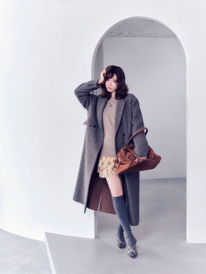 ティアードミニスカートにハイソックスを合わせ、グレーのチェスターコートを羽織った冬コーデ。ガーリーなミニ丈をきちんと感のあるアウターとサンダルで引き締めた、品のあるスタイリング。
