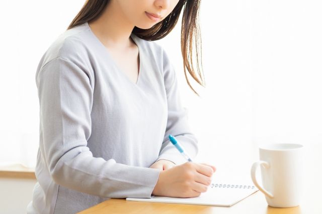 ノートを書く女性