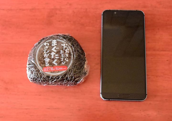 イオンの「おおきなおむすび まぐたく」と手持ちのスマートフォンを並べて比べてみました。