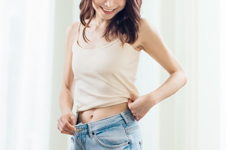 ダイエットに成功して喜ぶ笑顔の女性 