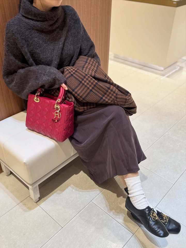 ディオールの赤いバッグを持つ女性