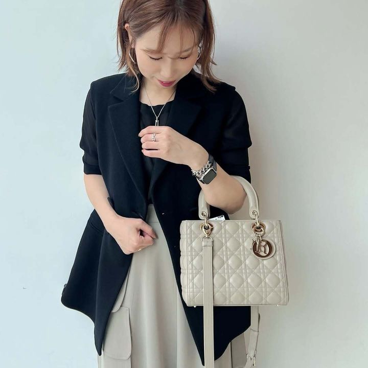 レディ ディオールの白いバッグを持つ女性