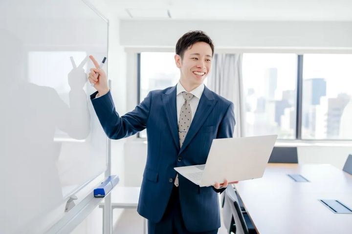 本部担当者がホワイトボードを使って加盟説明と運営支援を行う場面