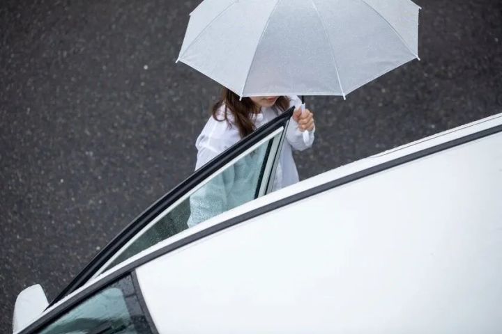 雨の日に車へ乗り込む女性の移動シーン