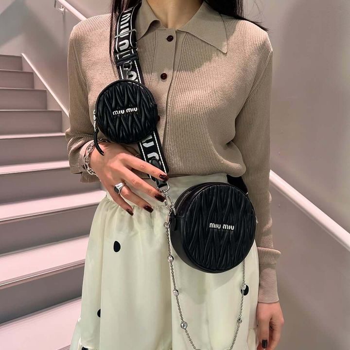 ミュウミュウのバッグチャームを複数付けた女性