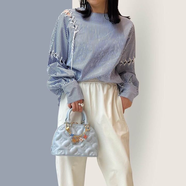 バッグチャームを付けたディオールのバッグを持つ女性