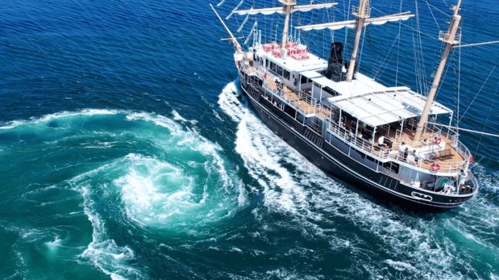 大型帆船とうず潮を空撮した迫力ある海上風景