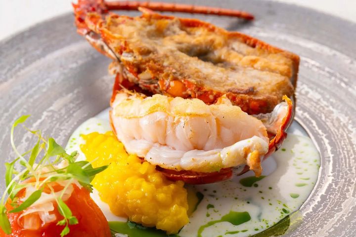 近海で獲れた伊勢海老をバターで丁寧に焼き上げた「伊勢海老のポワレ サフランライスとトマトのロティ ヴェルモットのソース」。