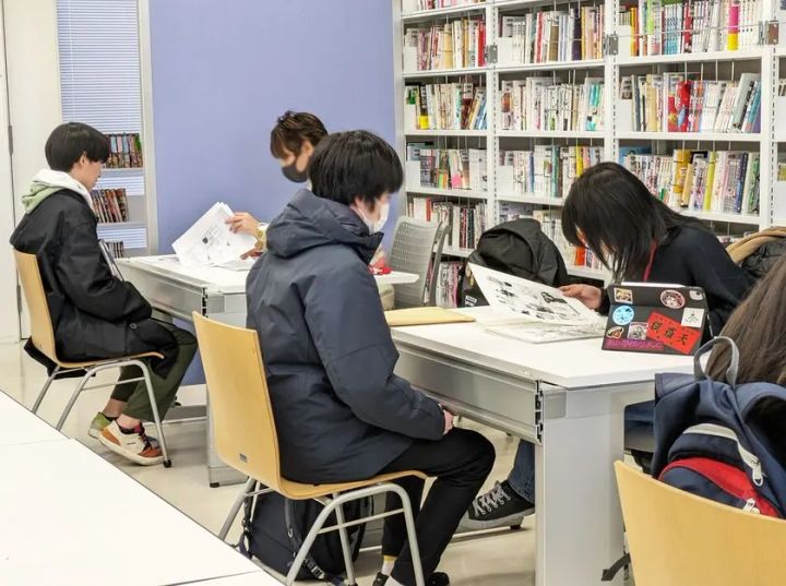 東京工芸大学マンガ学科の閲覧スペースで作品を読む学生たち