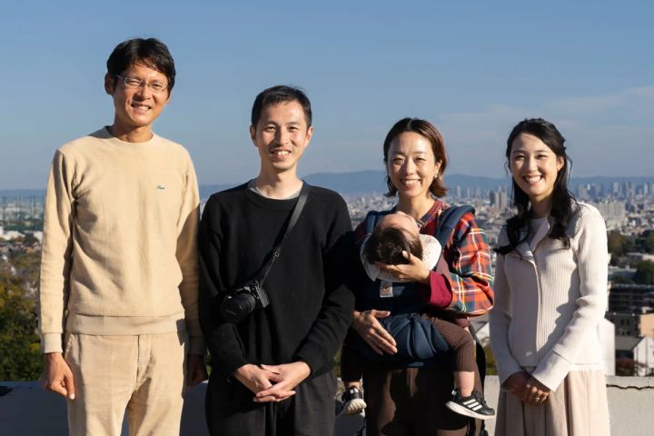 教主代行と建築家、家族が高台で並ぶ集合写真