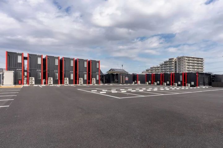 黒いコンテナと赤いパネルが印象的なHOTEL R9 The Yard 牛久の外観