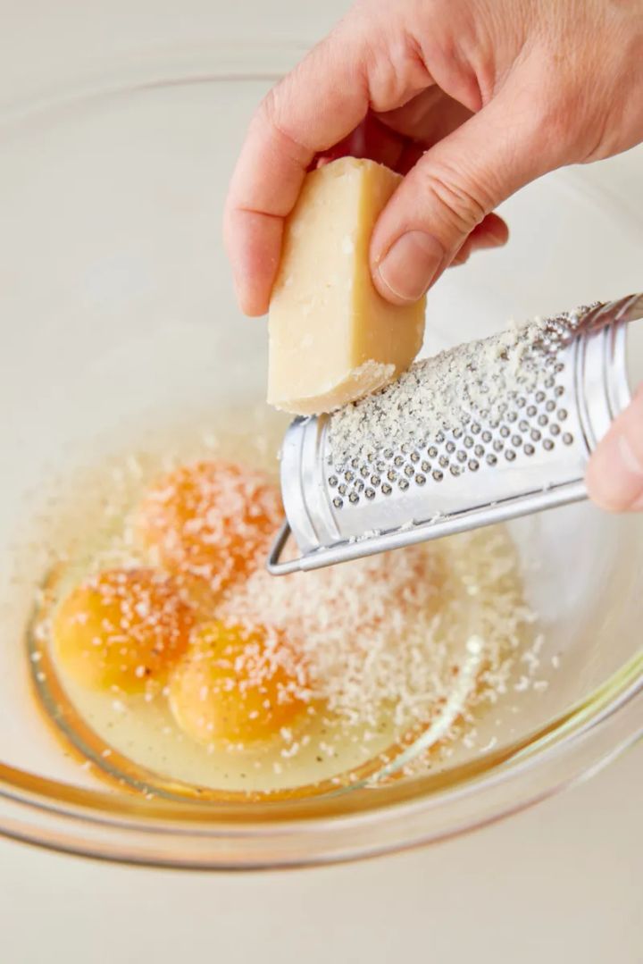 ボールに卵、卵黄を入れ、パルメザンチーズをすりおろして加える