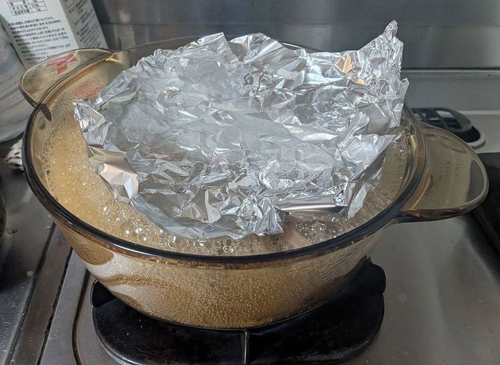 イラを泡煮中。落し蓋を持ち上げるほどの泡で魚を包み、その外側を一気に加熱して固めます