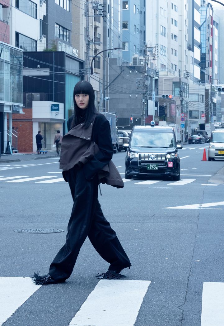 クラシックとモダンとを行き来する、自由な精神 <br /> 現代らしいゆったりとしたプロポーションの中に、異素材の組み合わせや独自のリズムを奏でるパターン使いなど、サカイらしいコードと遊び心が詰まったジャケットとパンツのセットアップ。洗練されたパリのランウェイでも、多様な価値観が混在する都市の路上でも、服から発せられる凛々しい存在感は、褪せることなくスタイリッシュに輝き続ける。コットンとウールを組み合わせたジャケット ￥253,000 パンツ ￥121,000 スカーフネックレス ￥63,800 シューズ 参考商品╱すべてSACAI（サカイ）