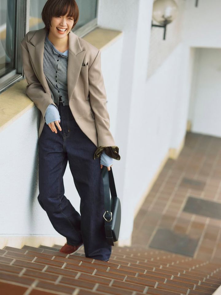 リラックスなデニムには緊張感のあるかっちりジャケットで大人トラッドなバランスが実現。デニム※3～4月発売予定￥29,920（オブラダ／シンチ） ジャケット￥33,000（クレドナ） カーディガン￥11,000、シアーロングTシャツ￥8,800（ともにアンヌーク／アンヌーク 新宿ルミネ2店） バッグ￥26,400（ヴィスク）、ベルト￥61,600（デアンシュ／ともにS&T） 手首につけたシュシュ￥1,650（アネモネ／サンポークリエイト） スニーカー￥31,900（デイト／ティースクエア プレスルーム）