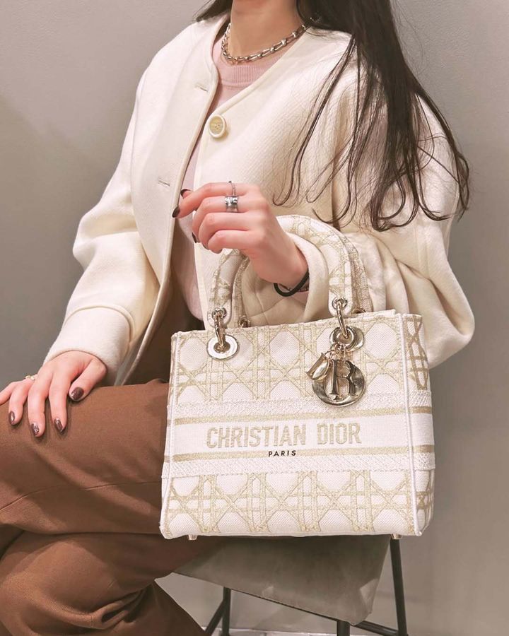 ディオールのバッグを持って椅子に座る女性