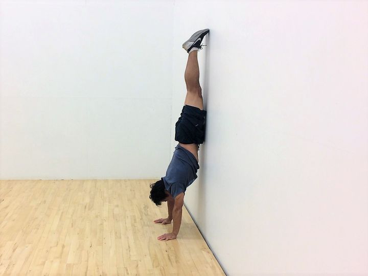 壁倒立、1本の棒のように逆立ちしている