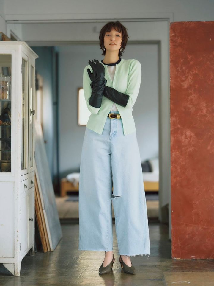 裾や部分的にあしらわれた程よいダメージ感がお洒落。デニムとトーンを揃えたカラーニットにレザーグローブでピリッと辛さを添えて。クラッシュデザインカーブデニム￥22,000（アングリッド） トップス￥20,900（アイアワク） ロングTシャツ￥17,380、レザーグローブ￥27,280（ともにオブラダ／シンチ） ベルト￥70,400（デアンシュ／S&T） シュシュ￥1,650（アネモネ／サンポークリエイト） ピアス￥27,500（フミエタナカ／ドール） カーキミュール￥20,700（ドゥーブル／サロン アダム エ ロペ）