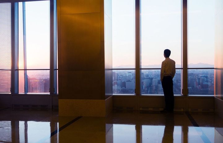 展望の開けたビルから街を見下ろしている男性
