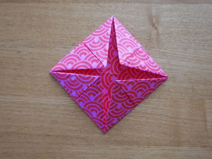 裏返して、また角を中心に向かって折ります。