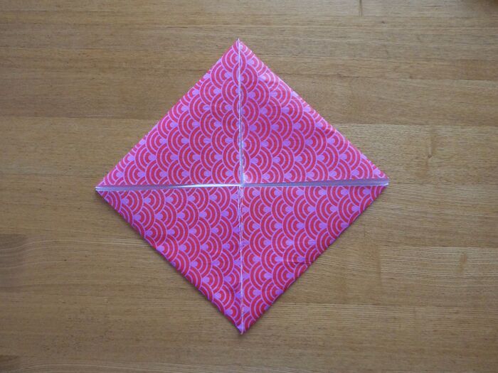 折り線に沿って、角を中心に向かって折ります。