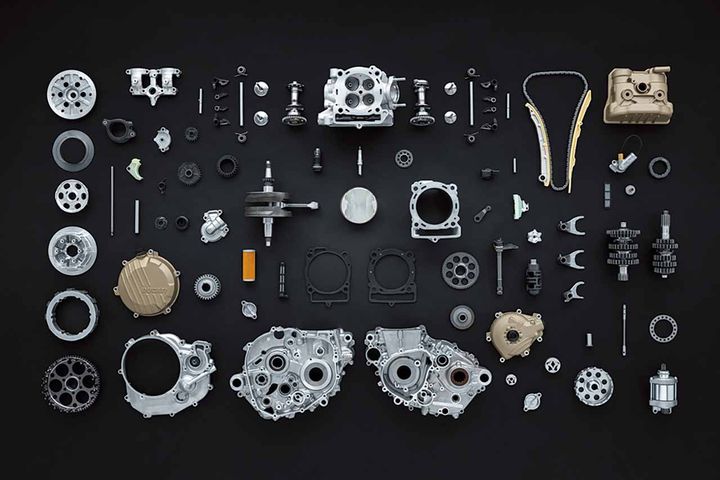 ドゥカティの象徴とも言えるデスモドロミック・バルブ駆動。MotoGPやスーパーバイク世界選手権で磨き上げられてきたこの独自機構が、Desmo450MXにも惜しみなく投入された。一般的なエンジンではバルブの開閉はスプリングによって行われるのに対し、デスモドロミックはカムによってバルブを強制的に開閉する独自方式。バルブの動きの正確性を高め、高回転時に起こりがちなバルブジャンプを根本から排除する。スプリングを使わない構造は低回転域での摩擦抵抗低減にも貢献するため、アクセルに対する反応が鋭くなり、回転が落ち込みやすいモトクロス特有のシチュエーションでもエンジンは素直にトルクを発生する。レブリミットは11,900rpmと、450MXとしては異例の高回転設定を実現。回せるエンジンであると同時に、ギヤシフト回数を減らせるというレースに直結するメリットも生まれている。ヘッドカバー、クラッチカバー、オルタネーターカバーにはマグネシウムを採用し、乾燥重量は26.8kg。アップ専用クイックシフター（4,000rpm以上で作動）も標準装備する。メンテナンスサイクルは、ピストン交換およびバルブクリアランス点検が45時間、メインエンジンサービスは90時間と、実戦使用を前提とした設定だ。