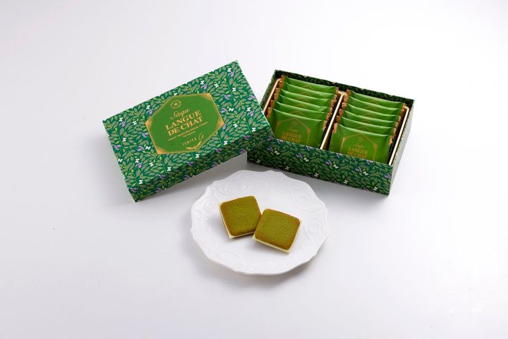 「サク ラング・ド・シャ（抹茶ミルク）」12枚入 ¥1,458 こちらは単品の詰め合わせ。愛知県・西尾の抹茶をホワイトチョコに加え、ほんのり抹茶風味のラング・ド・シャでサンドした一品。ティーリーフをベースとしたデザインに、北海道のエゾシロチョウとラベンダーが描かれた爽やかなパッケージ。