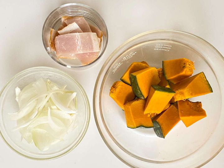 ベーコンは1cm幅に切る。玉ねぎはうす切りにする。かぼちゃは1～1.5cm角に切る。